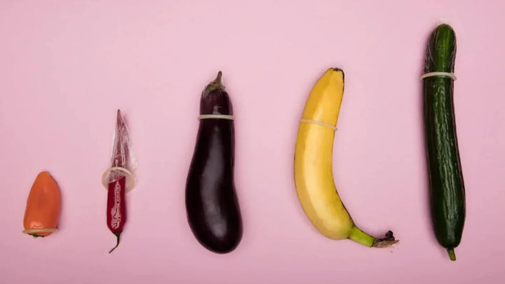 Assortment of vegetables and fruits arranged by size on pink background. 