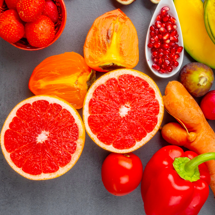 Colorful fruits and vegetables including grapefruit, pomegranate, and red peppers rich in anti-oxidants
