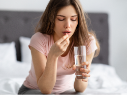 Woman taking daily supplement with water to support immune health